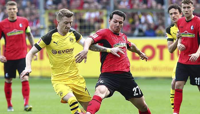 Marco Reus (Dortmund) im Infight mit Freiburgs Nicolas Höfler. (© imago images / DeFodi) SC Freiburg - Borussia Dortmund Tipp